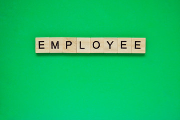 Word employee. Wooden blocks with lettering on top of green background. Top view of wooden blocks...