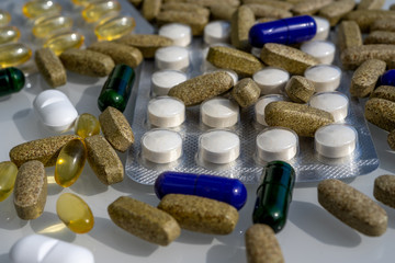 Close-up of different pills and capsules are on the table from virus. Selective focus. Assorted pharmaceutical medicine pills, tablets and capsules. 
