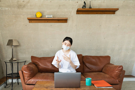 woman with protective face mask working at home
