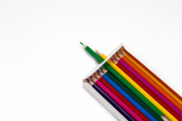 Colored pencils in a box isolated on a white background.
