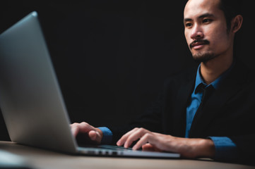 handsome confident businessman in suit working with laptop
