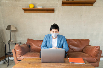 man with protective face mask working at home