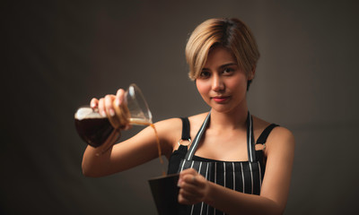 female barista pours boiling water into the coffee glass, making a cup of coffee drip filter