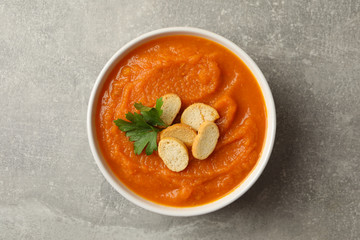 Bowl of pumpkin puree on gray background, top view