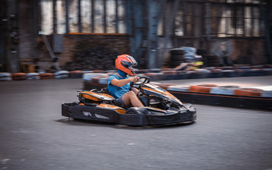 Male driving a kart on an indoor track - obrazy, fototapety, plakaty