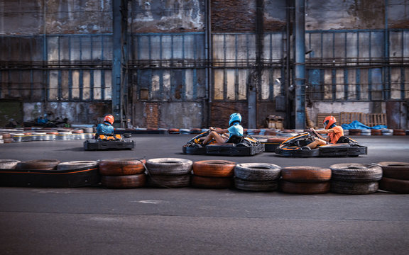 Three guys overtaking each other on an indoor karting track