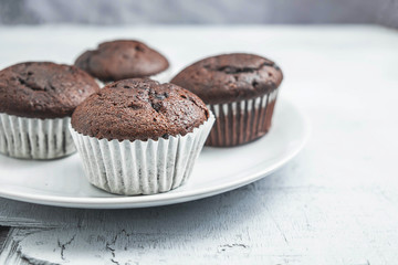 bakery chocolate cupcakes in a dish on a white background