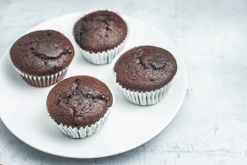 bakery chocolate cupcakes in a dish on a white background