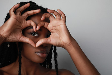Fototapeta premium Close-up of beautiful dark-skinned lady draws attention to great cool event, sale, discount message. Space for text.
