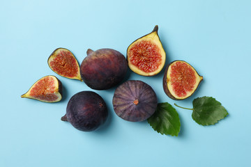 Fresh fig fruits and slices on blue background, top view