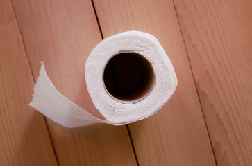 Simple toilet paper on wood background.