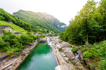 Fototapeta na wymiar View from Bridge Ponte dei Salti to Verzasca River at Lavertezzo - clear and turquoise water stream and rocks in Ticino - Valle Verzasca - Valley in Tessin, Switzerland