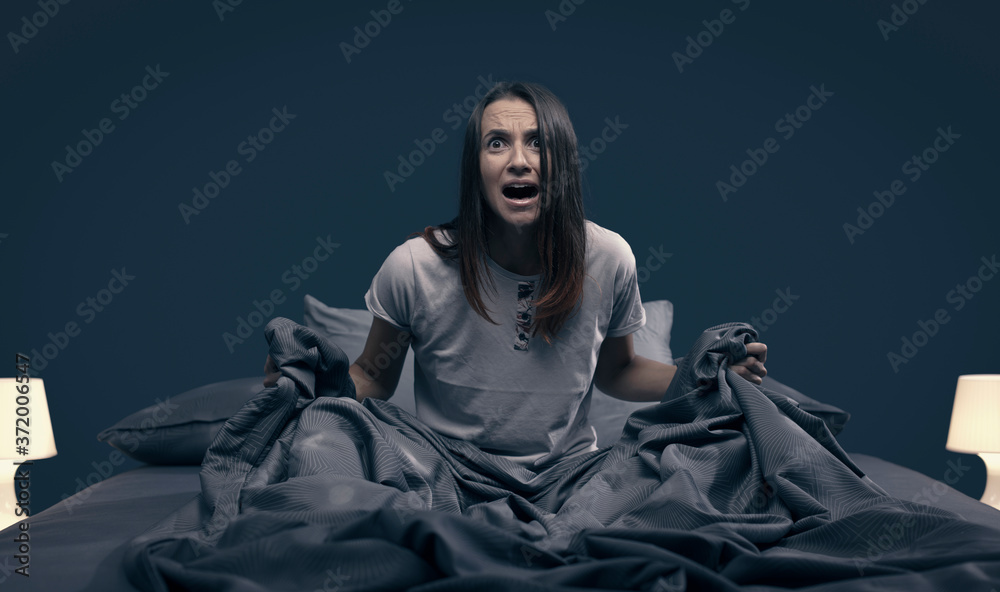 Wall mural shocked woman waking up from a nightmare