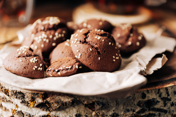 Teapot with black tea and homemade chocolate cookies on a brown natural wooden background