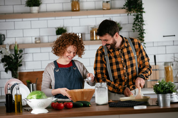 Young couple making delicious food at home. Loving couple enjoying in the kitchen..