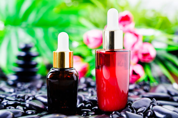 Cosmetic glass bottle for essential oils on black stone