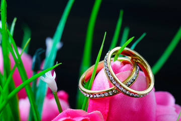 Wedding ring resting in a fake pink tulip flower