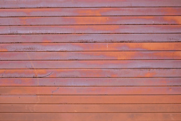 The wall is made of old rusty metal.