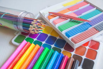Fototapeta premium Bright beautiful colored pencils, felt-tip pens, watercolors, plasticine, everything for children's creativity.