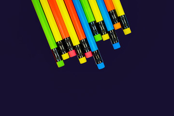 Different colored wood pencil crayons scattered across a blue background