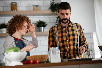 Young couple making delicious food at home. Loving couple enjoying in the kitchen..