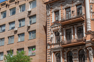 Fototapeta na wymiar Kyiv (Kiev), Ukraine - August 08, 2020: Two buildings which were built during different periods and which have very big architectural difference, first building is pre-revolutionary, second is Soviet 