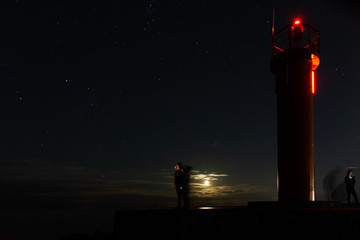 Lighthouse in the sunset and the moon rise