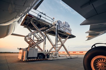 Loading of cargo containers to airplane - obrazy, fototapety, plakaty