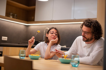 Couple eating in the kitchen late at night