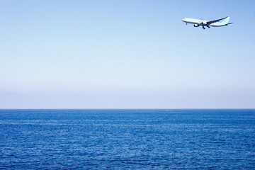 Fototapeta na wymiar Airplane flying over the sea.