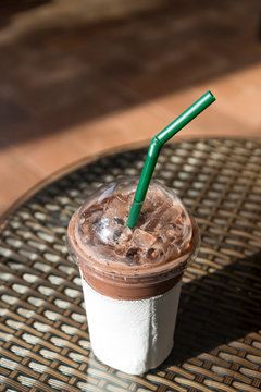 Iced chocolate in take home plasttic cup on glass table