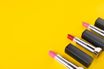 female bright lipsticks on mono colour yellow background