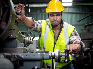 Confident factory workers are customizing machines in preparation for the production of industrial...