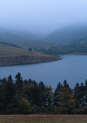 lake and mountains in foggy conditions 