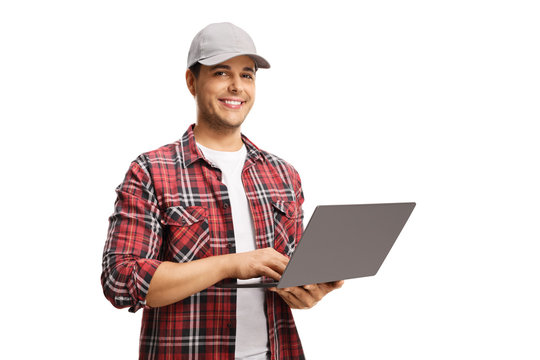 Young man with a cap holding a laptop computer and smiling at the camera