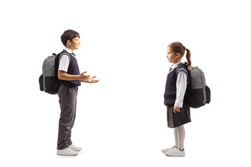 Full length profile shot of schoolchildren in uniforms talking