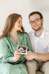 A young family is waiting for a baby, the husband hugs his pregnant wife. How to prepare for having a baby together and keep a warm relationship after childbirth