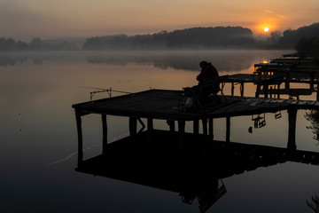 Naklejka na ściany i meble fisherman on Jenoi pond near Diosjeno, Northern Hungary