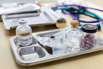 Coronavirus 2019.Testing of coronavirus vaccine.A syringe with the COVID-19 vaccine, against the background of drugs, pills, and medical supplies.