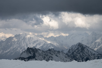 Fototapeta na wymiar Evening high mountain scenery snow-covered rocky steep mountains of the main mountain range of the northern Caucasus