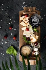 Flat lay composition with different types of delicious cheese on slate board