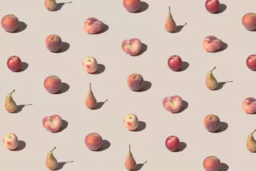 Kreatives Muster aus frischen Pfirsichen und Birnen auf pastellbeigem Hintergrund. Minimales Sommerfrucht-Layout. © Zamurovic Brothers