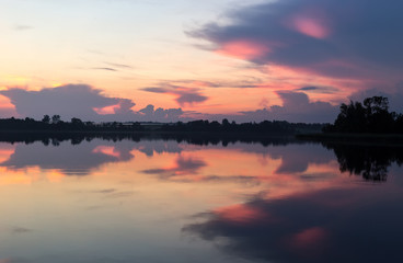 Fototapeta na wymiar Sunset summer horizon mirrored in a lake