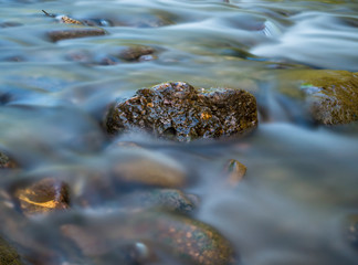 Long exposure picture of water stream flowing. Smooth water background texture.