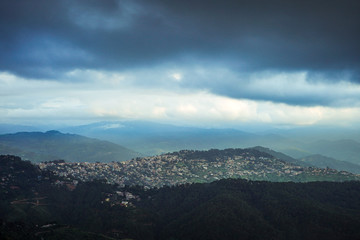 Landscape of a city situated on the top of the mountain with clouds in the sky.