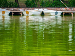 Obraz premium Boats parked by the wooden pier at the edge of the lake.