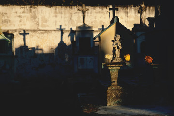 Graves on the cemetery with last sunlight and cross shadows, Merida, Yucatan, Mexico