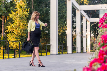Naklejka premium A pregnant woman standing in front of a modern building