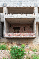 Ruins of a destroyed Soviet building with a landscape overgrown with trees