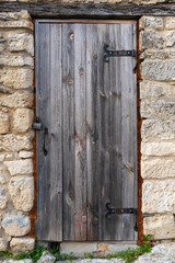 Old wooden door in an ancient stone wall